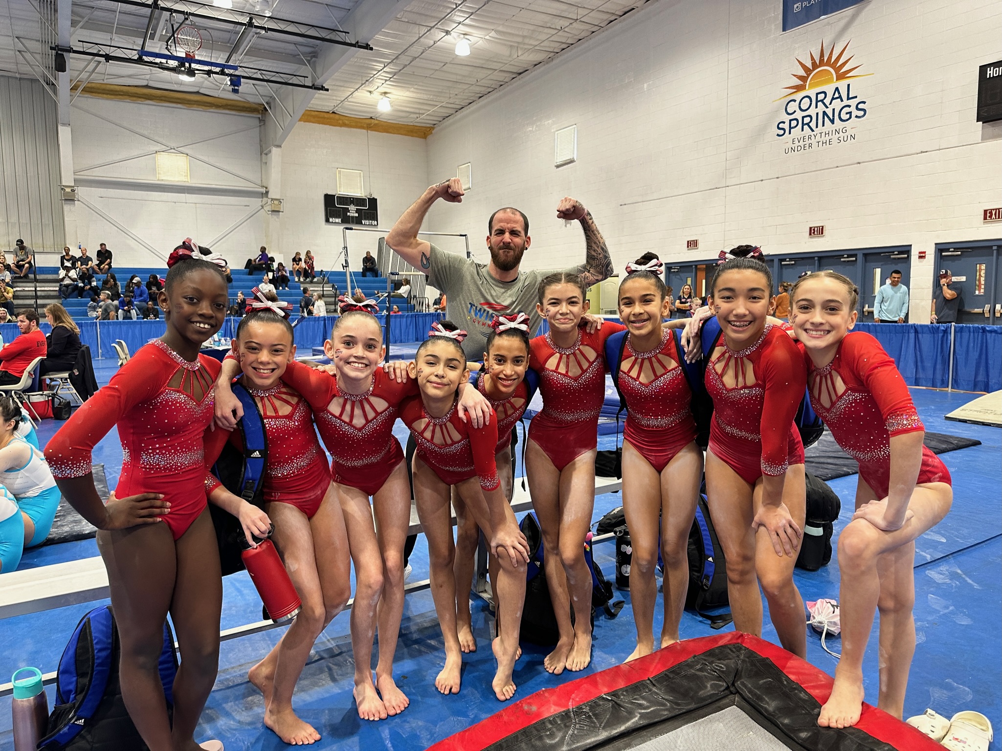 American Twisters gymnasts in red leotards at the Sun And Surf Spectacular meet